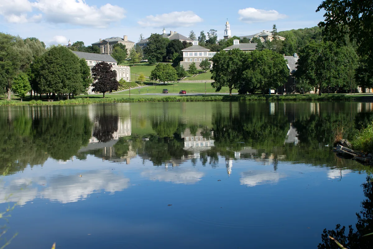 Colgate University’s hillside campus and Memorial Chapel reflected in Taylor Lake